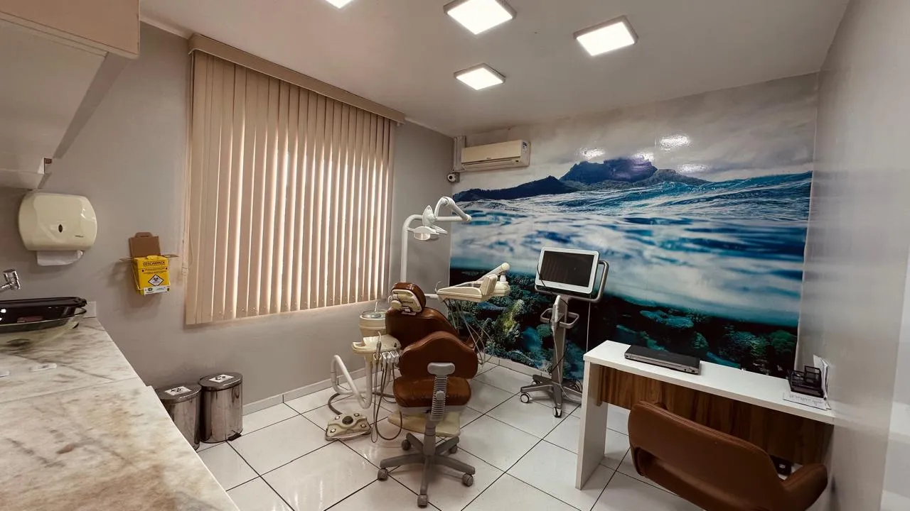 Consultório com painel decorativo do mar na parede e cadeira caramelo